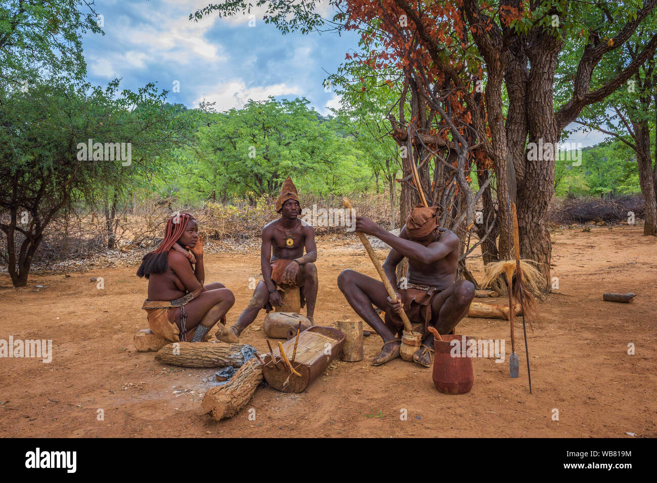 La gente de la tribu Himba sentado y haciendo sus herramientas Foto de stock