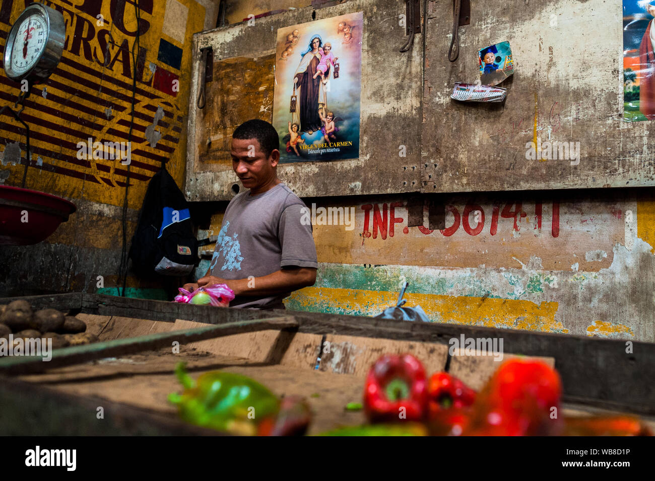 Un mercado afrocolombiana vendedor vende pimientos rojos y patatas en el mercado de Bazurto en Cartagena, Colombia. Foto de stock