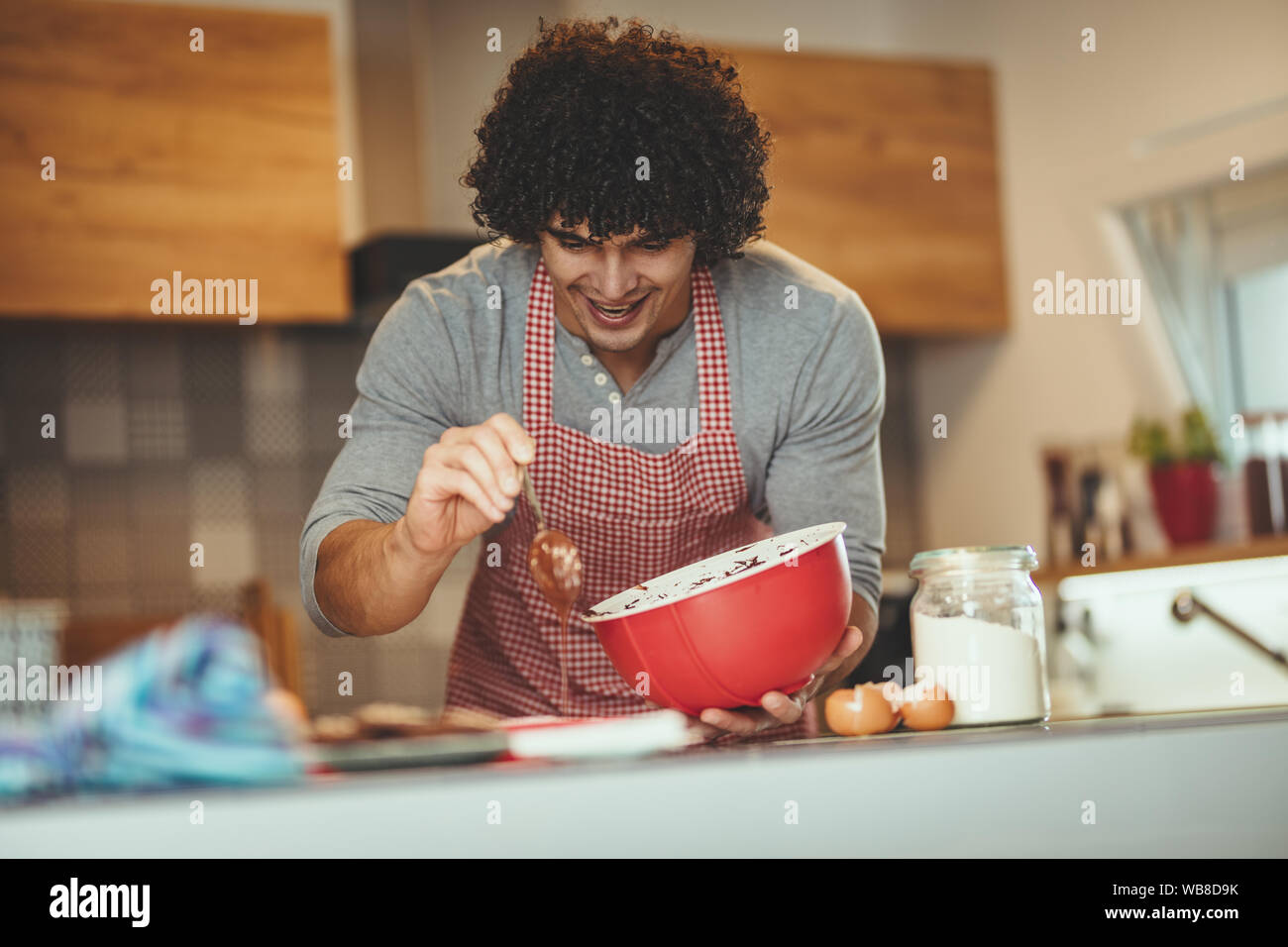Joven Apuesto Hombre Hacer Galletas En Su Cocina Para Sus Amigos El Se Vierte La Masa De Chocolate En Los Moldes Fotografia De Stock Alamy