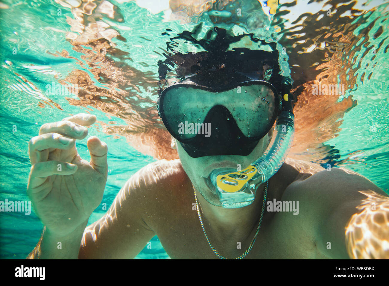 Guapo divertirse en vacaciones y haciendo un selfie submarina durante el buceo en el mar. Foto de stock