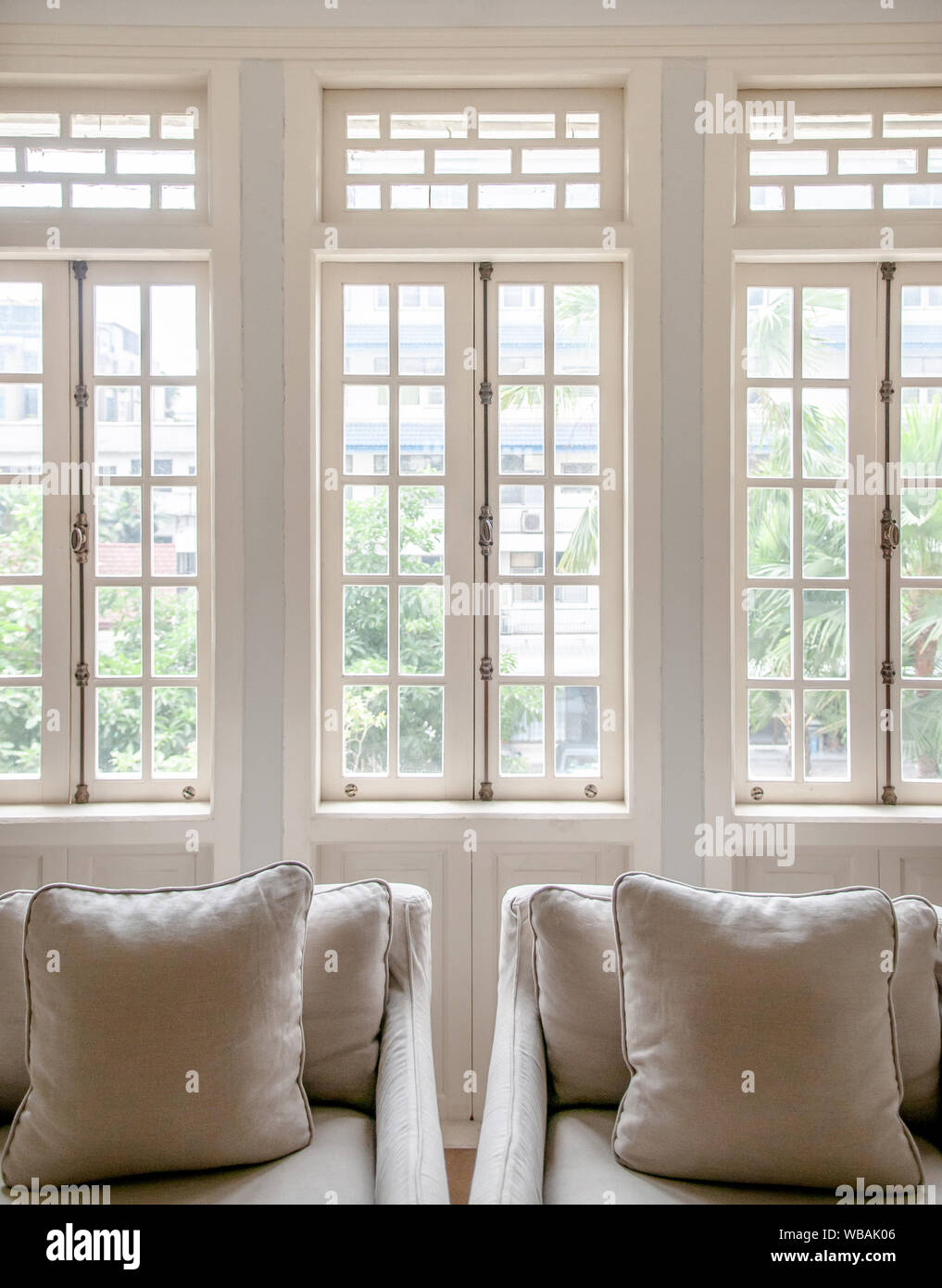 Colonial blanco vintage salón con sillones y clásico diseño minimalista  almohada, acogedor salón con luz natural a través de ventanas Fotografía de  stock - Alamy