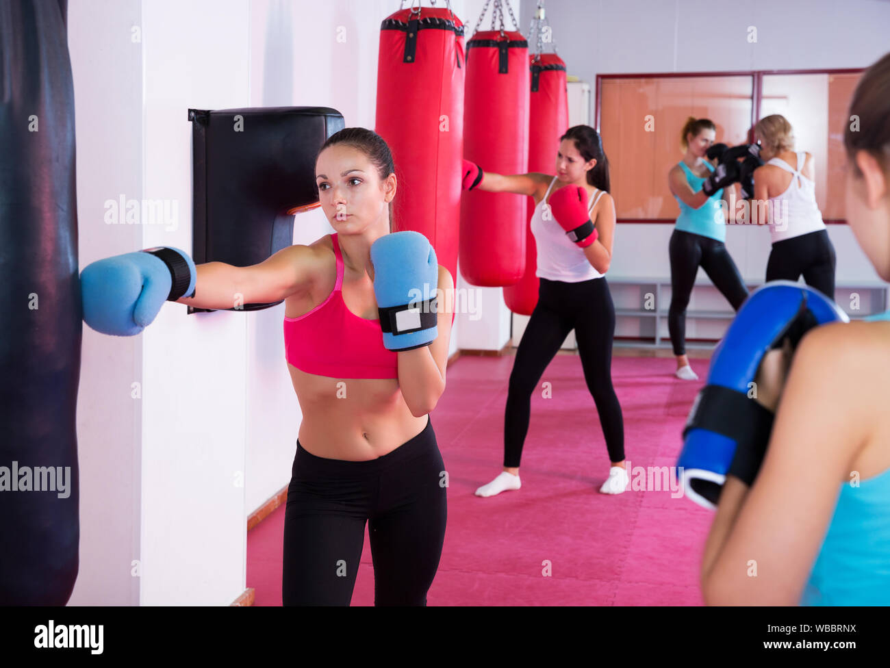 Es femenina activa haciendo ejercicios con saco de boxeo en el gimnasio  deportivo Fotografía de stock - Alamy