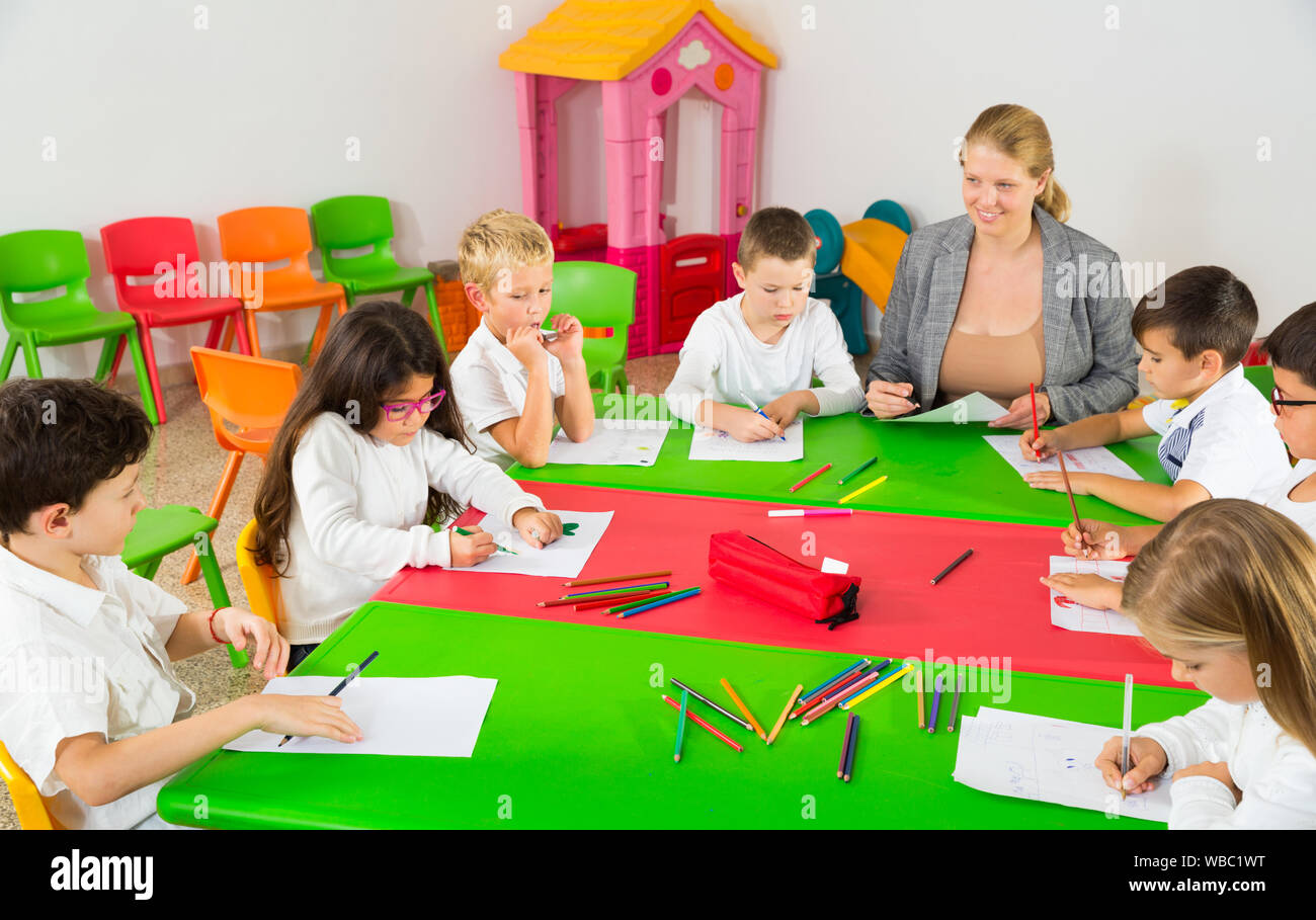 Amable Maestra Hablando Con Los Niños Sentarse Juntos Alrededor Del Escritorio En El Aula 7798