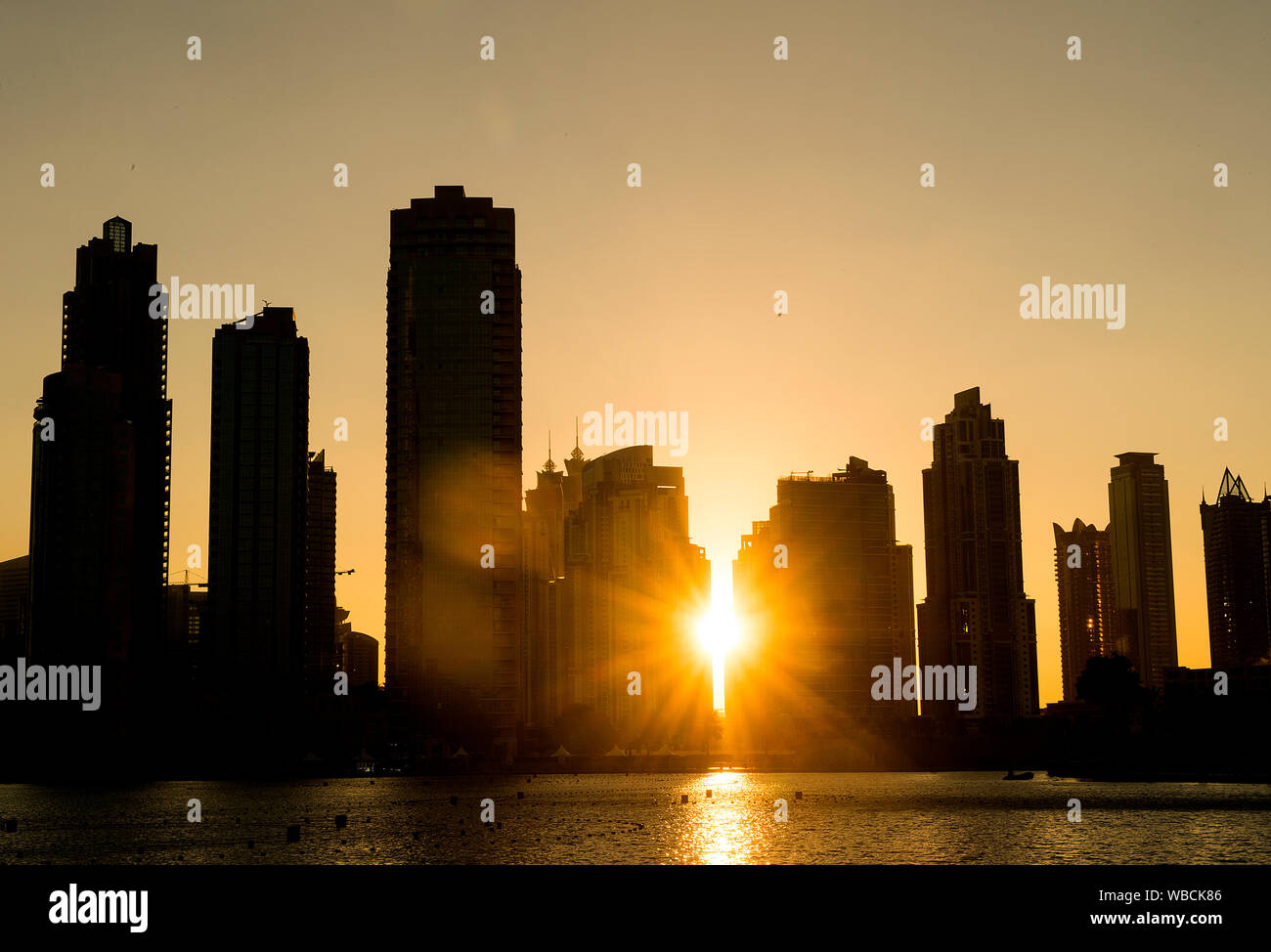 La puesta del sol sobre el horizonte de la ciudad de Dubai. Foto de stock