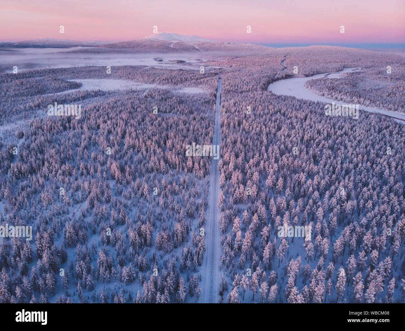 Carretera nevada y bosques nevados vistos desde arriba en Laponia Foto de stock