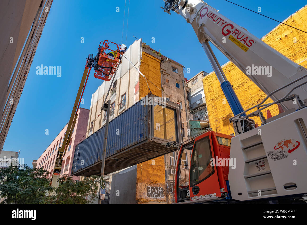 Barcelona, España. 26 Aug, 2019. El primer módulo de vivienda se considera elevada por una grúa.conferencia de prensa la instalación del contenedor del proyecto (APROP) alojamiento temporal para familias