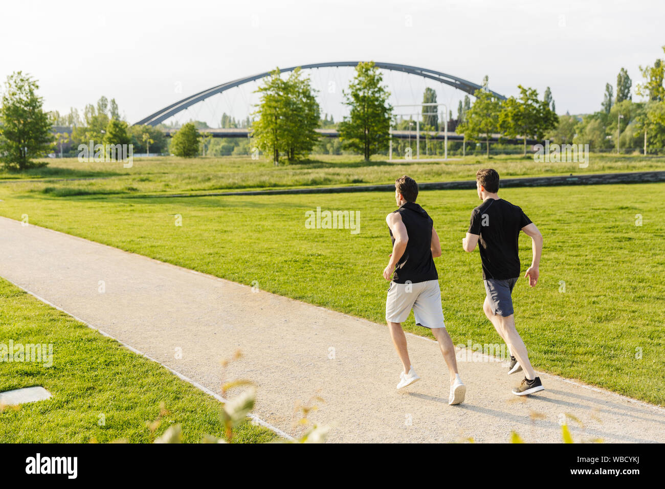 Imagen de dos hombres en ropa de trabajo muscular y ejecutarlo en el Green  Park al aire libre en la mañana Fotografía de stock - Alamy