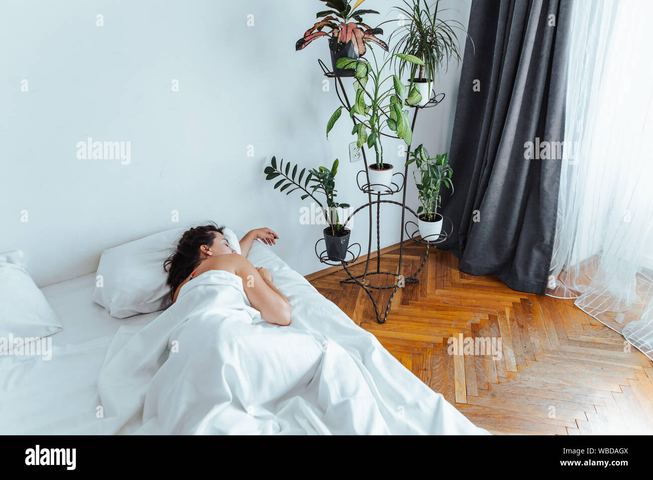 Mujer patinando en cama con sábanas blancas la luz solar en la ventana  Fotografía de stock - Alamy