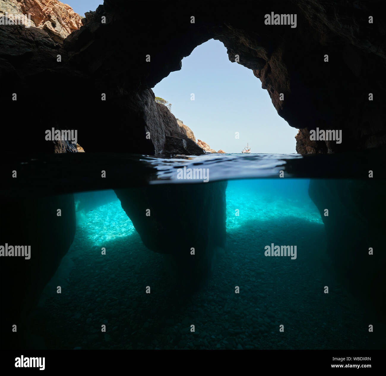 Sobre y bajo el agua dentro de una cueva con varias aberturas en la orilla del mar, España, Mediterráneo, Costa Brava, Cataluña, Calella de Palafrugell Foto de stock