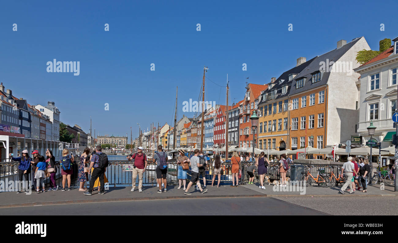 El Puente Nyhavnsbroen, Nyhavn, donde los turistas obtengan los mejores selfies o fotos de antiguos barcos de vela, histórico canal casas coloreadas y barcos de crucero Foto de stock