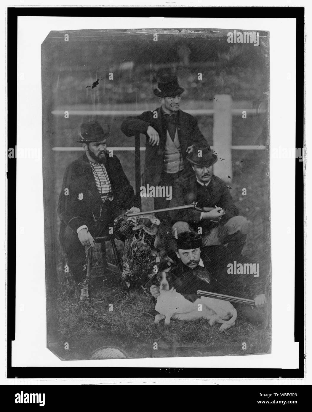 Longitud completa de cuatro hombres que plantean con rifles, perro de caza, y un refuerzo de las aves de caza Resumen/medio: 1 : Impresión fotográfica tintype. Foto de stock