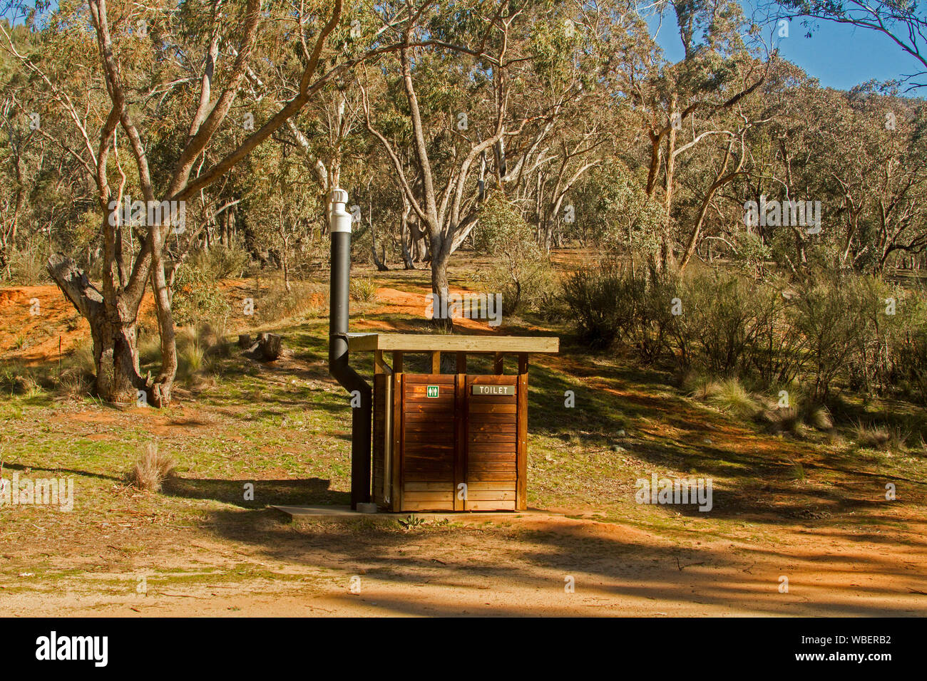 Edificio de madera, Bush wc, dunny, fosa loo, wc larga caída, entre bosques de grandes árboles de eucaliptos en la zona de picnic rural en Nueva Gales del Sur (Australia) Foto de stock