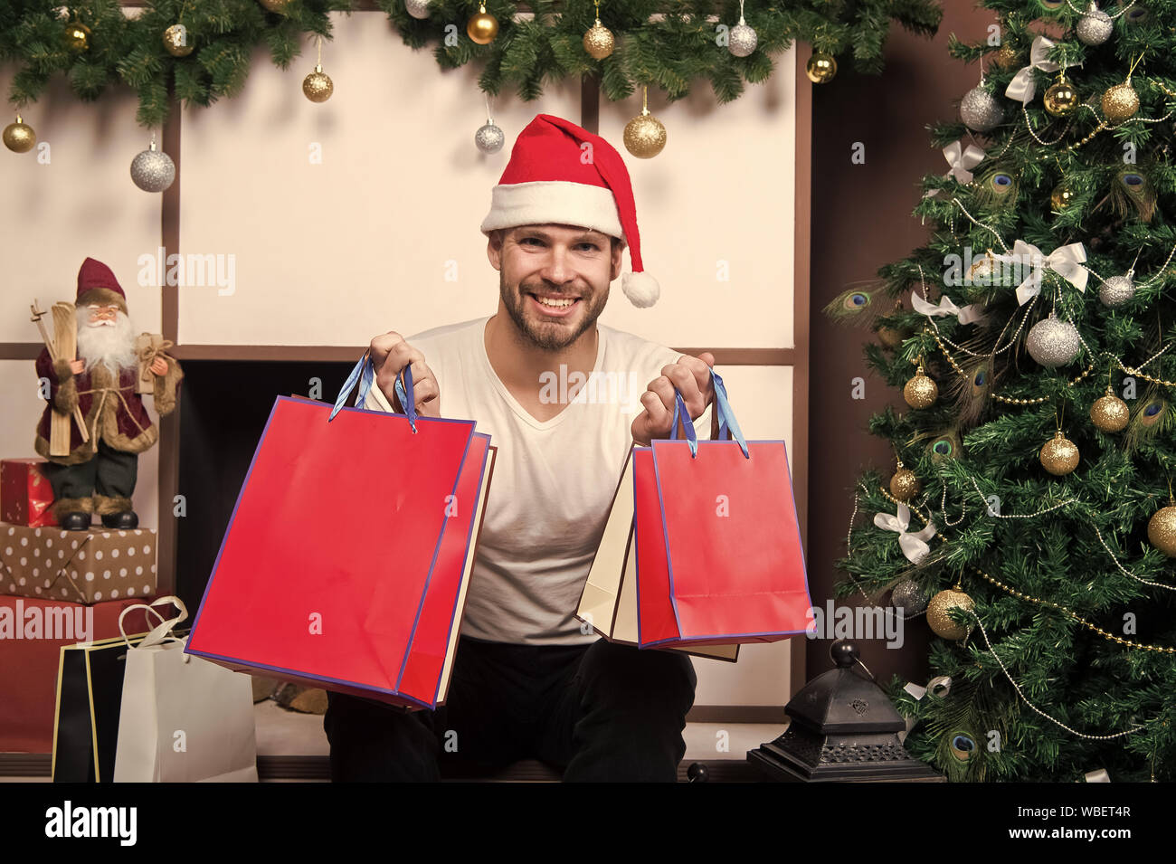 La entrega de regalos de Navidad Compras de Navidad online. Escena de año  nuevo con el árbol y los regalos. Hombre de gorro de Papá Noel para  celebrar la Navidad. La mañana