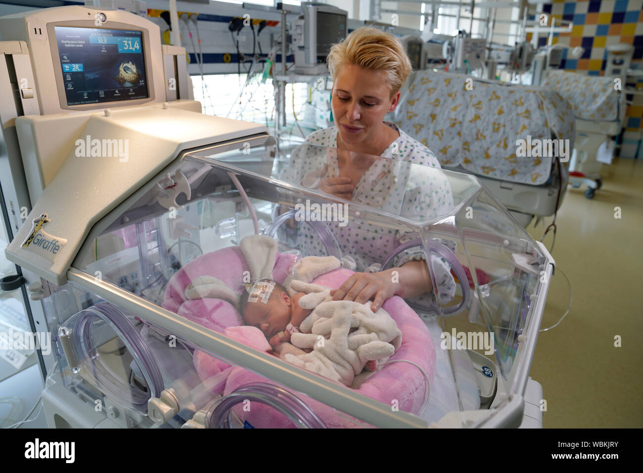 Madre de gemelos con uno de sus hijos en una incubadora, unidad de cuidados intensivos para recién nacidos, Karlovy Vary, República Checa Foto de stock