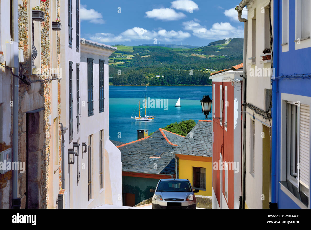 Hermosa vista desde un callejón estrecho a bahía con veleros fondeando en el agua Foto de stock