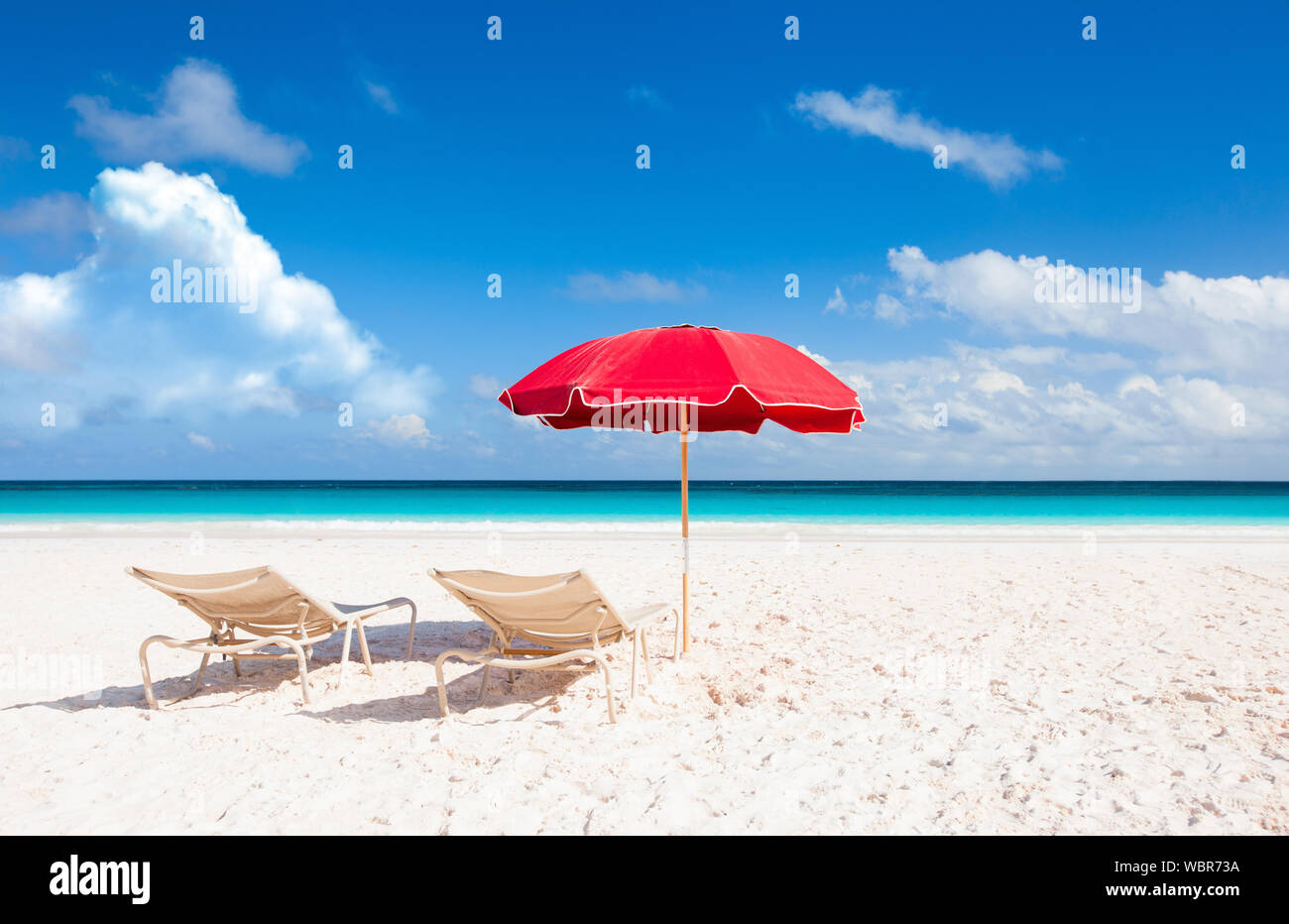 Escena de verano en la playa con sombrilla roja Foto de stock