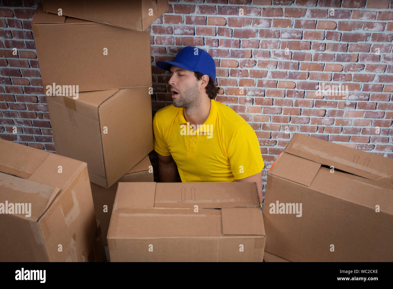 Mailman brasileño durmiendo en un depósito con un montón de cajas. Foto de stock