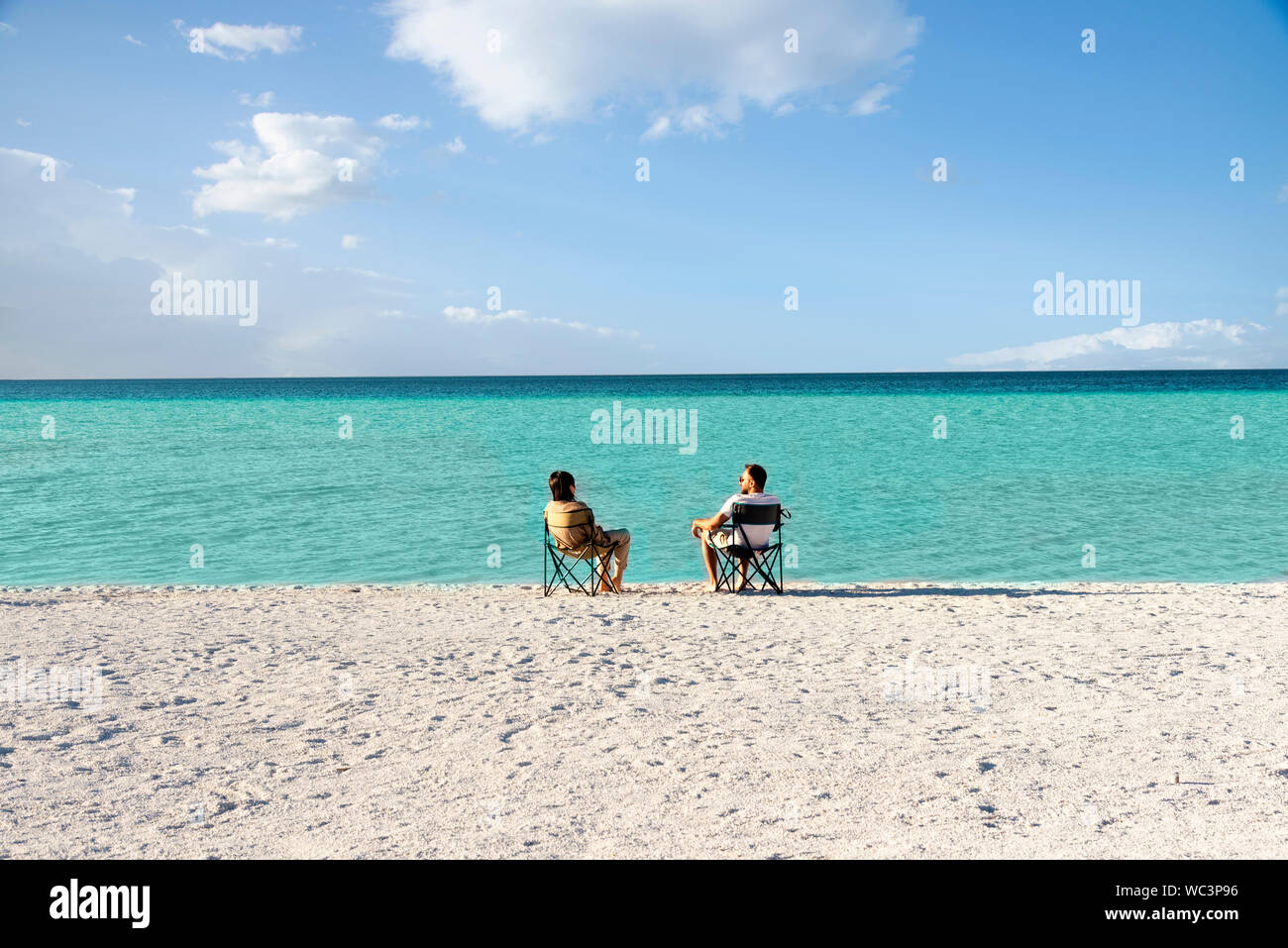 Salda lago como Maldivas, con arenas blancas y aguas color turquesa. Una pareja sentados en sillas portátiles cerca de la orilla del agua. Burdur / Turquía. Mou Foto de stock