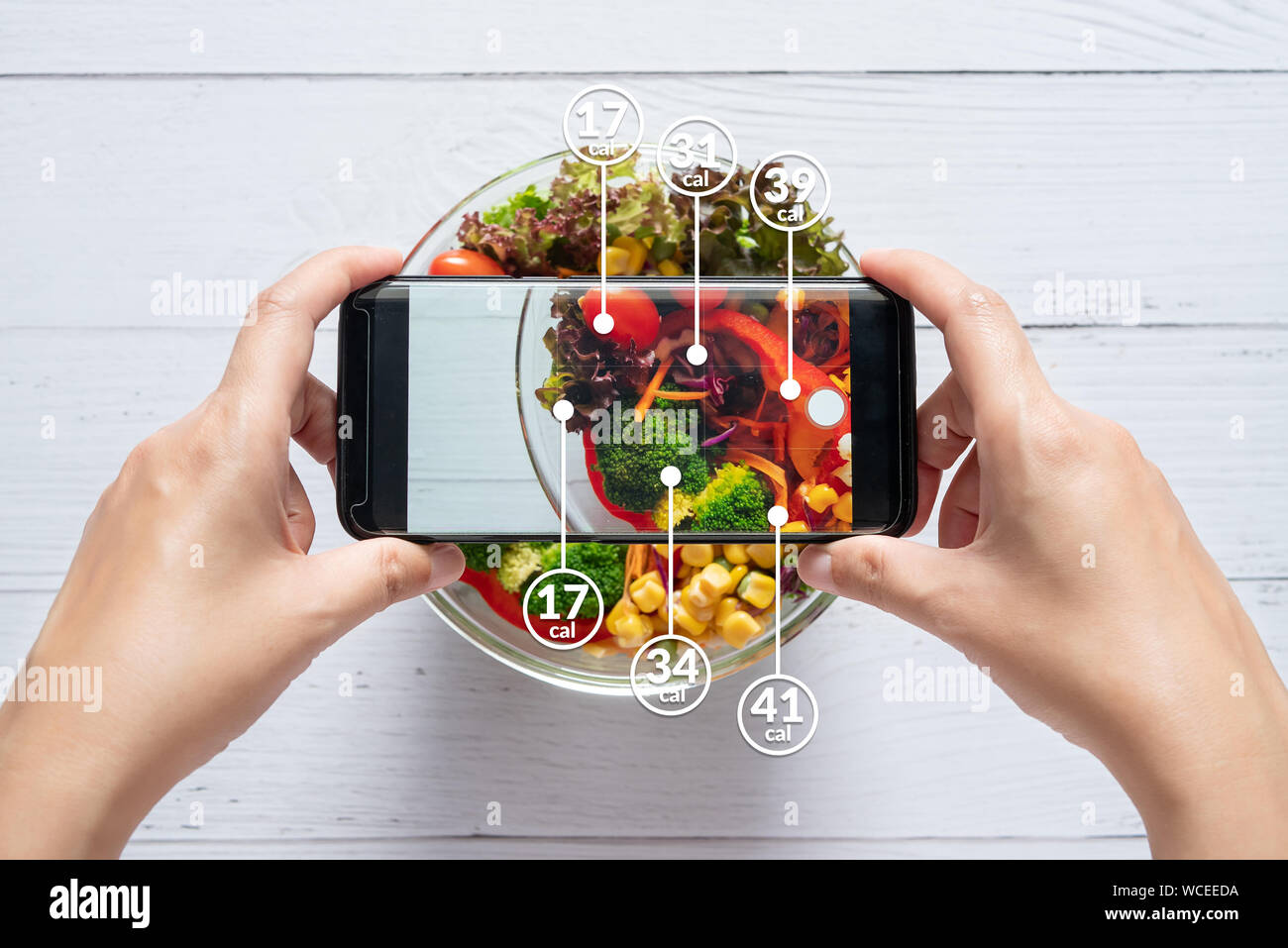 Conteo de calorías y el control de los alimentos concepto. Mujer usando la aplicación en el smartphone para escanear la cantidad de calorías en los alimentos antes de comer Foto de stock