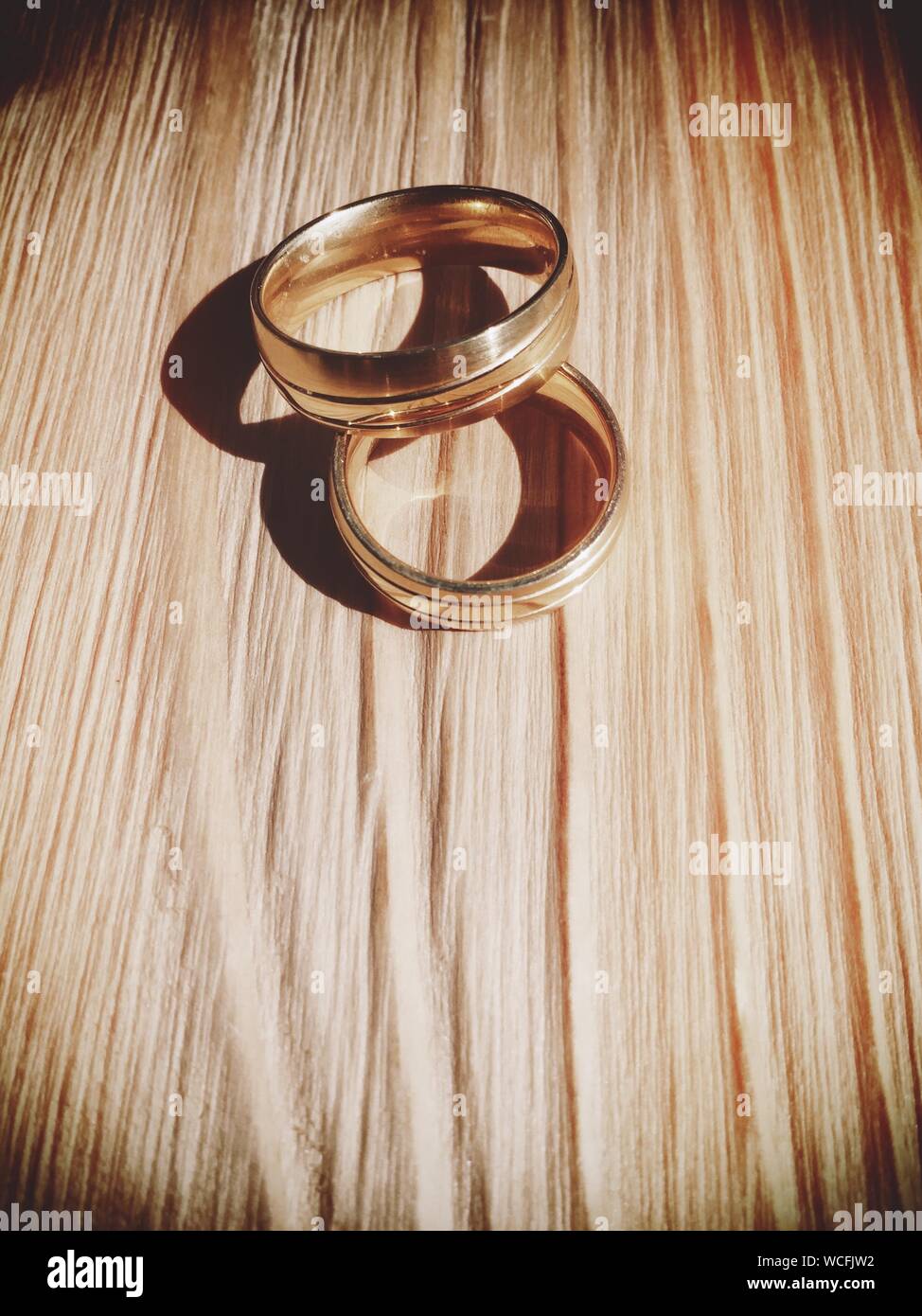 Los anillos de boda Sobre la plancha de madera. Foto de stock