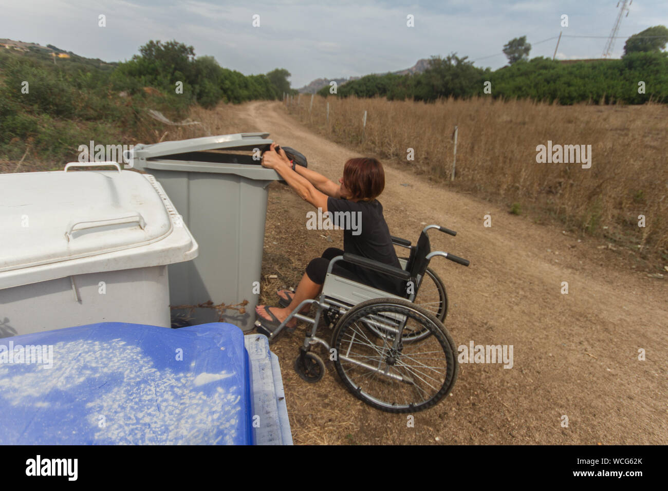 Niña discapacitados en silla de ruedas en la vida cotidiana haciendo  reciclaje Fotografía de stock - Alamy