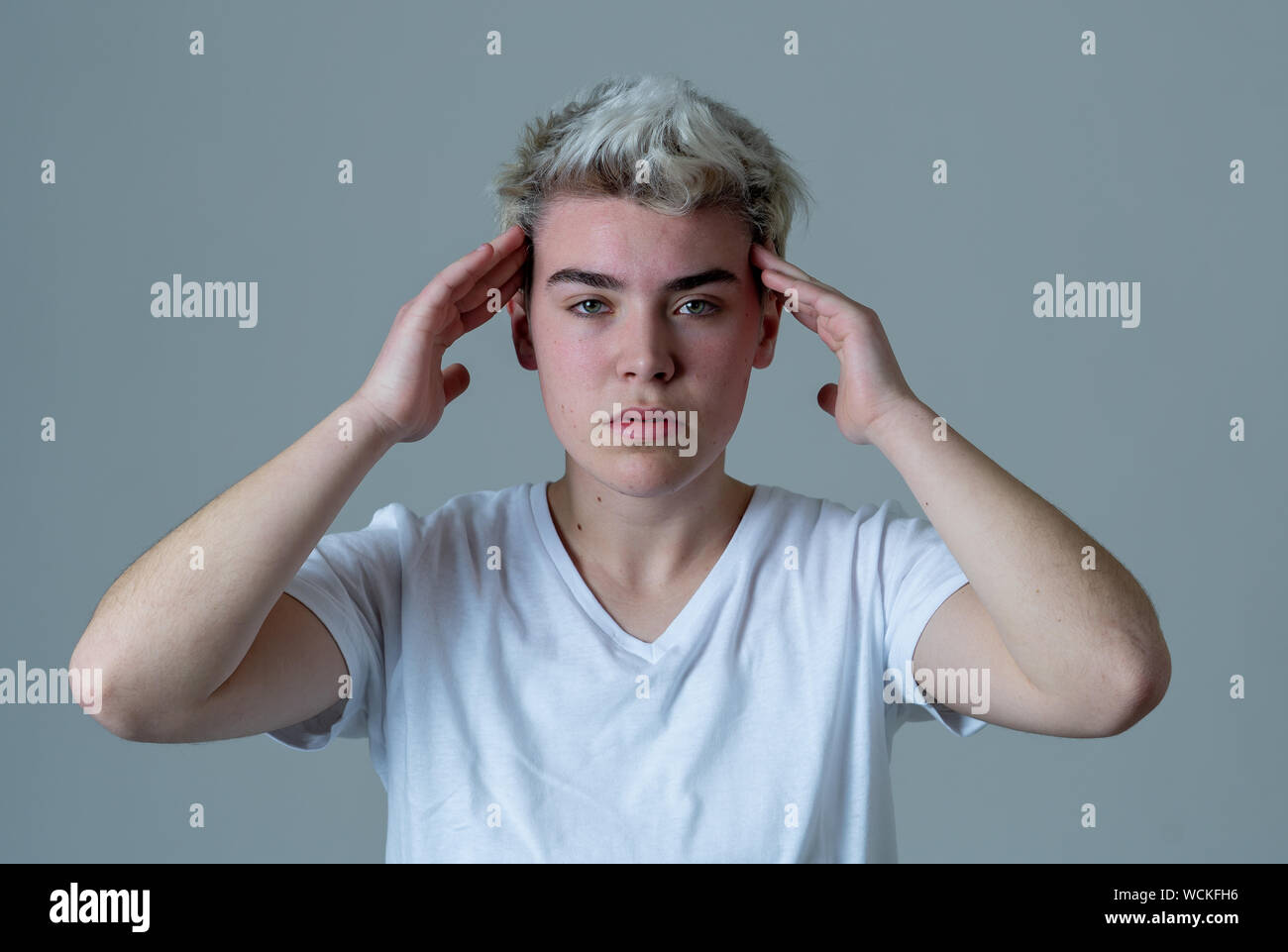 Retrato de un joven adolescente transgénero mirando preocupado y reflexivo que sufren migrañas y el dolor emocional. La gente de la diversidad y la identidad de género Foto de stock