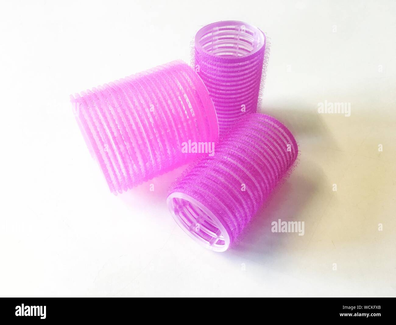 Close-up de rizadores de pelo rosa en la mesa Foto de stock