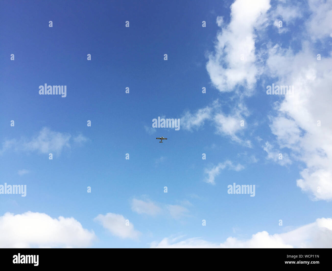 Ángulo de visión baja del avión en mitad del aire contra el cielo Foto de stock