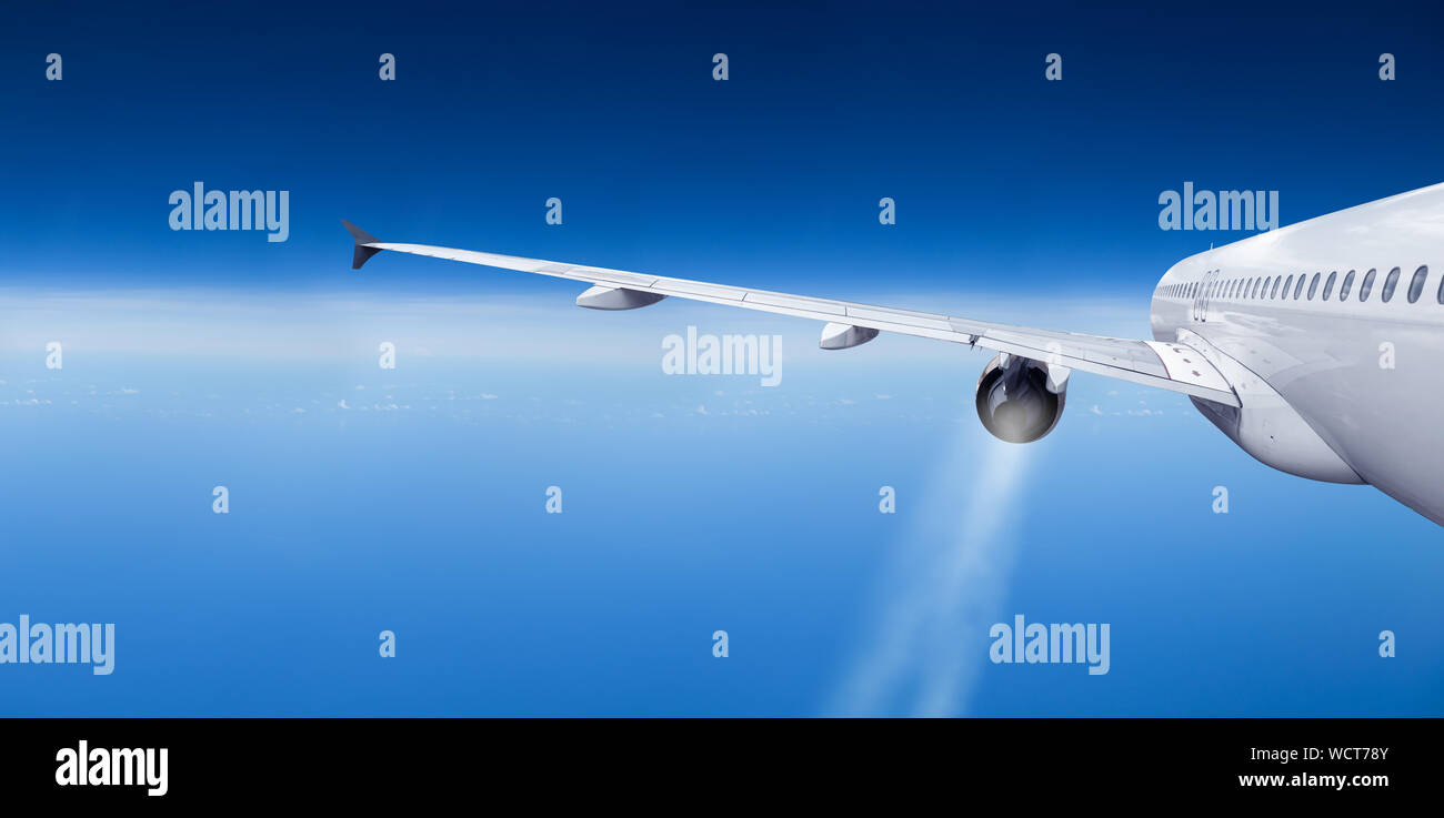 Vista exterior del avión de aerolíneas de pasajeros vista trasera con las estelas de vapor de la turbina del motor jet en azul cielo nuboso panorama amplio fondo con espacio de copia Foto de stock