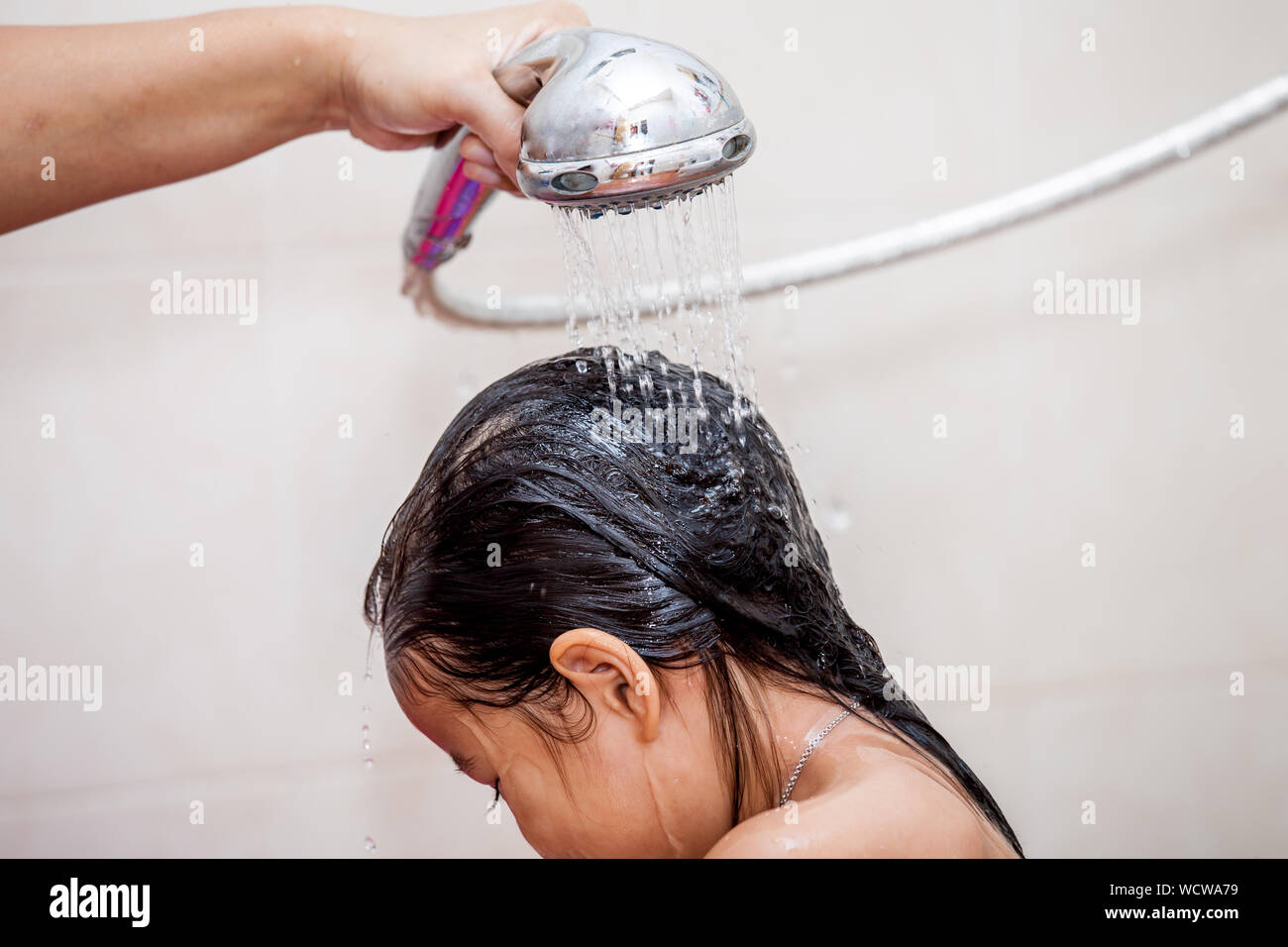 Mano recortada de persona duchándose chica en el baño Fotografía de stock -  Alamy