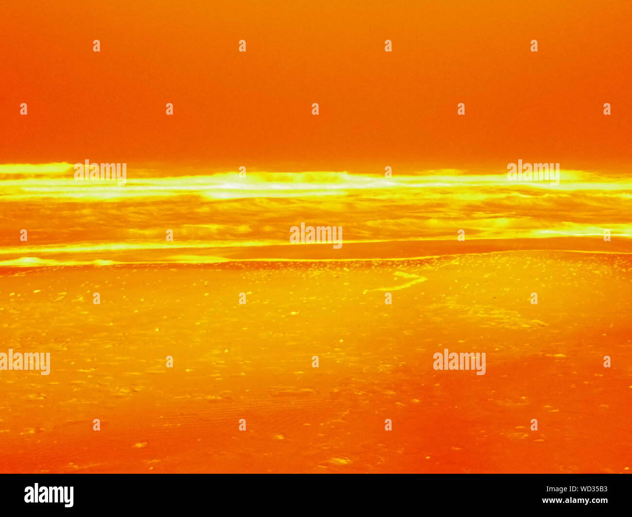 Nivel de agua la superficie vista del mar contra el cielo anaranjado al atardecer. Foto de stock