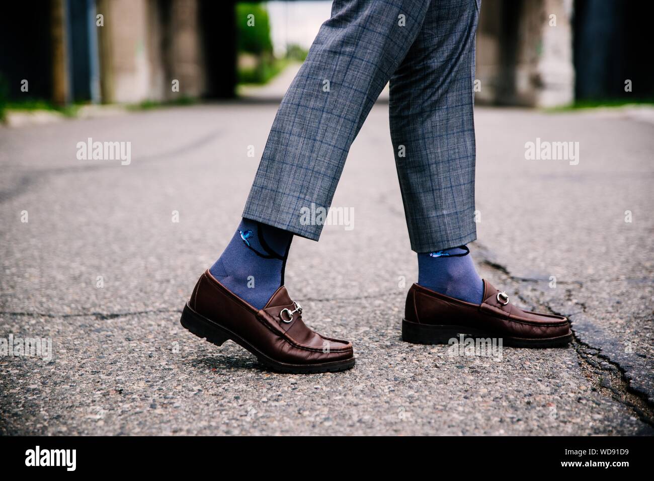 Disparo de cierre selectivo de una persona que lleva pantalones azules y.  zapatos marrones con calcetines azules Fotografía de stock - Alamy