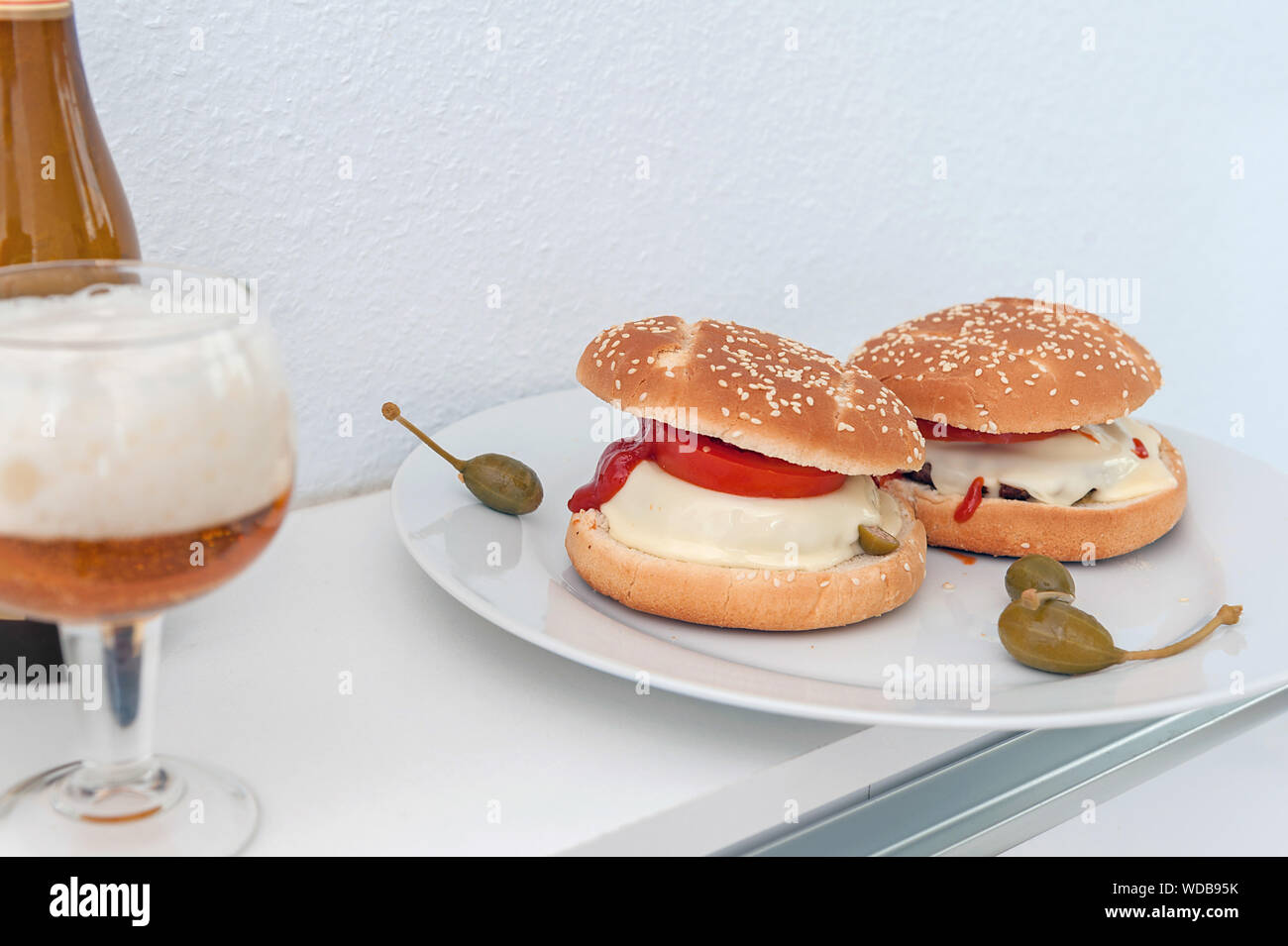 Hamburguesas con queso casero plato y vaso de cerveza. Imagen horizontal. Foto de stock