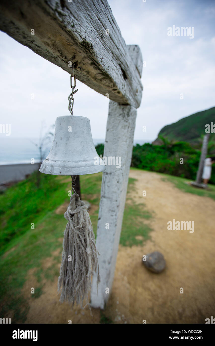 Bell colgando de madera en campo Foto de stock