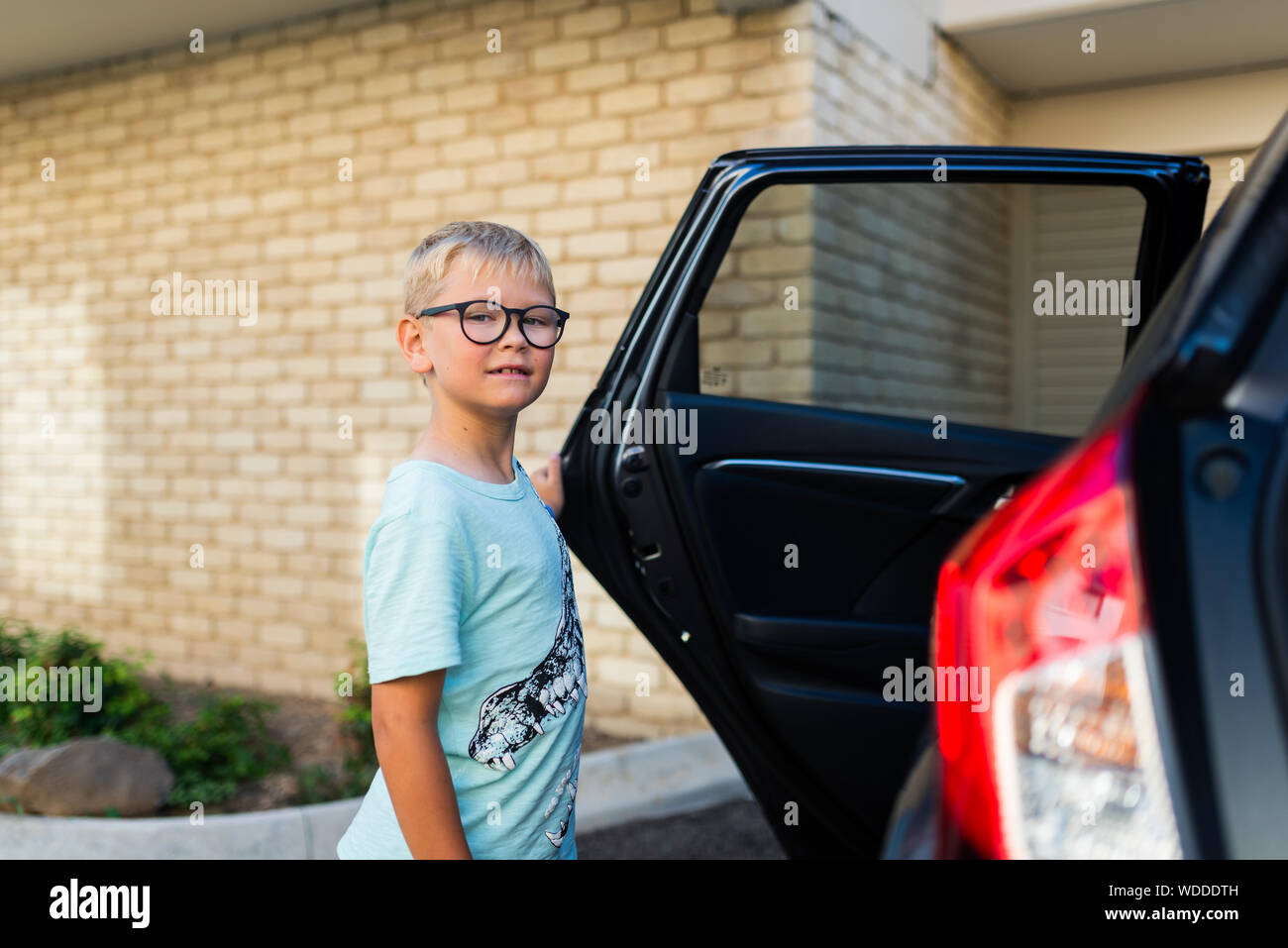 Muchacho por abrir puerta del automóvil Foto de stock