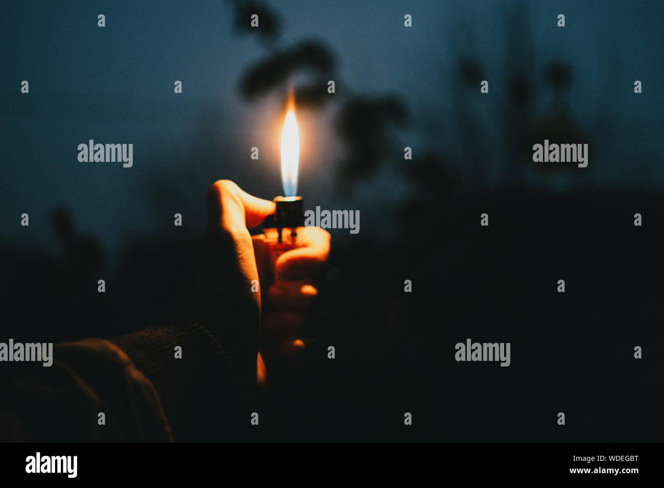 Close-up de mano sujetando encendedor iluminado Fotografía de stock - Alamy