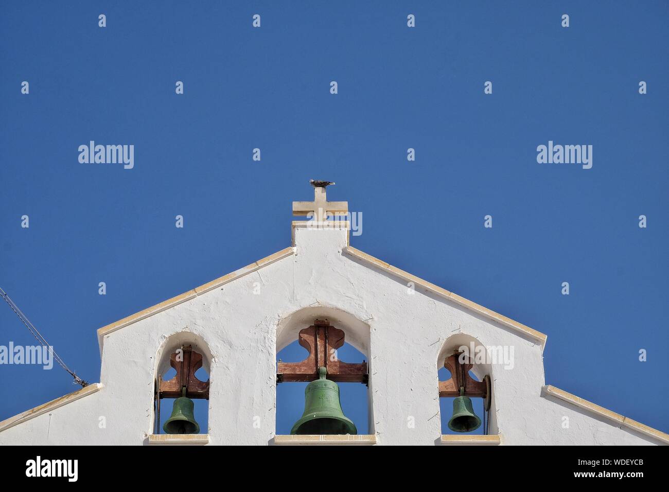 Ángulo de visión baja del campanario de la Iglesia contra el cielo azul claro Foto de stock