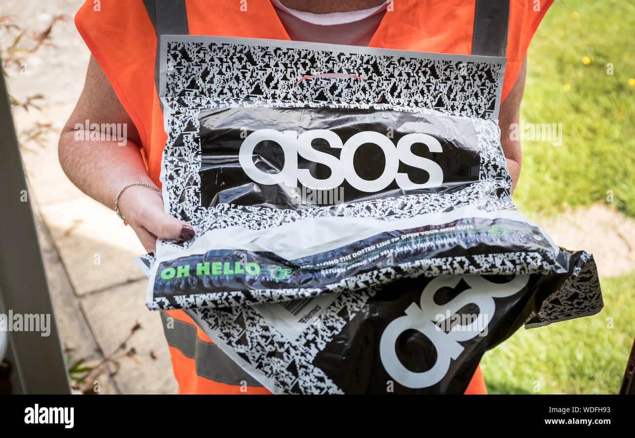 Una mujer ofrece un paquete de Aso, la ropa de online website Fotografía de - Alamy