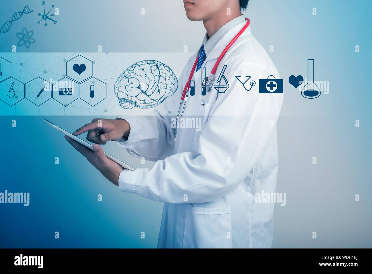 Imagen Digital de médico utilizando Tablet por diversos símbolos contra el fondo azul. Foto de stock