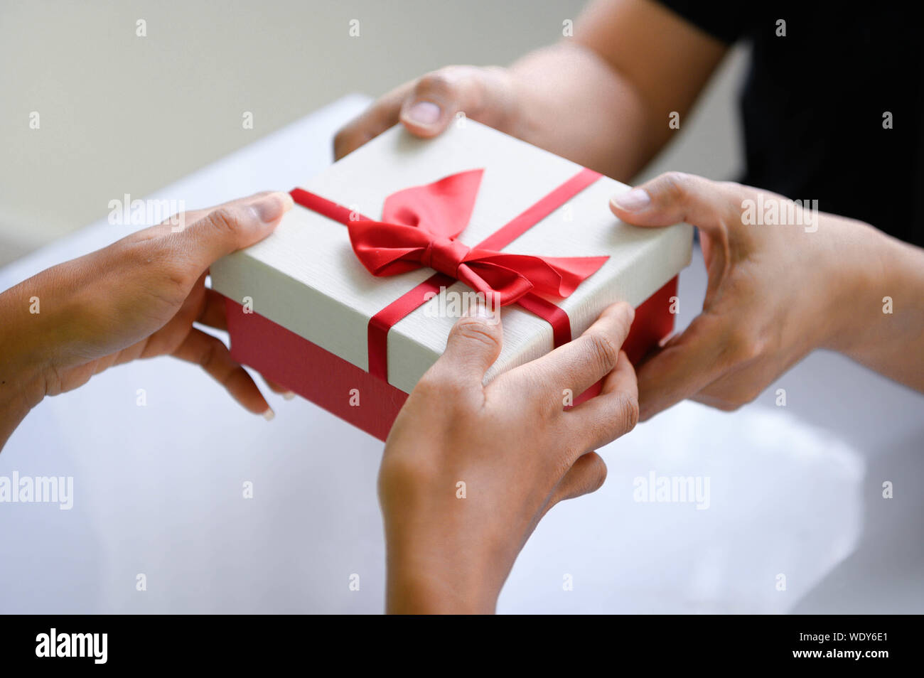Primer plano de manos dando caja de regalo en el día de Navidad y el  festival de año nuevo a cada uno de los demás. Festividades y eventos.  Giftbox sorprendente en citas