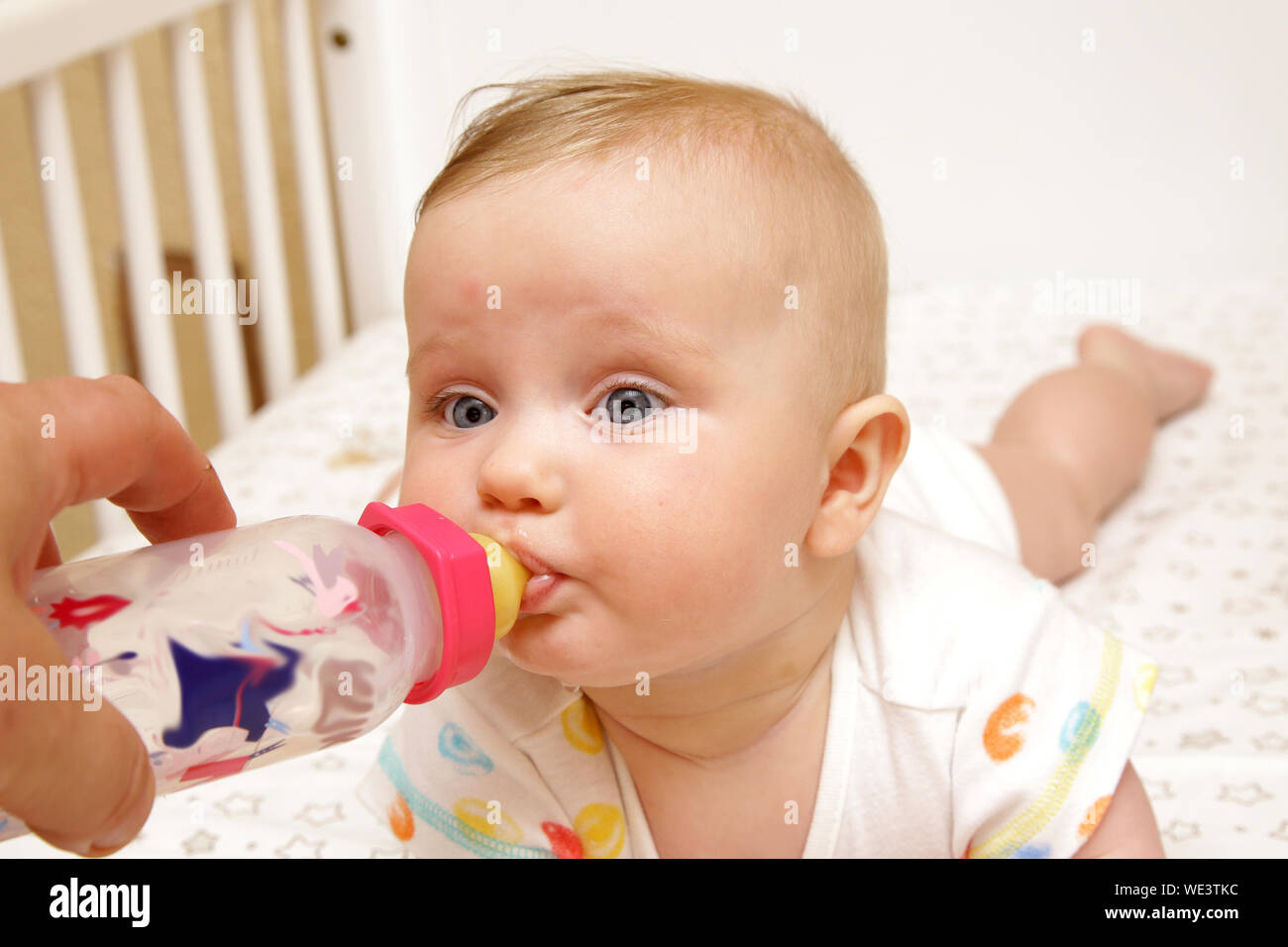 Unión niña niño recién nacido ingiere leche de biberón de agua aislados los  6 meses de edad Fotografía de stock - Alamy