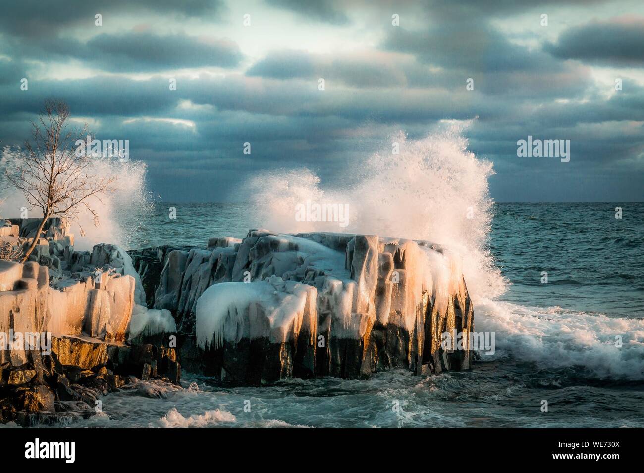 Olas rompiendo sobre las rocas en la costa Foto de stock