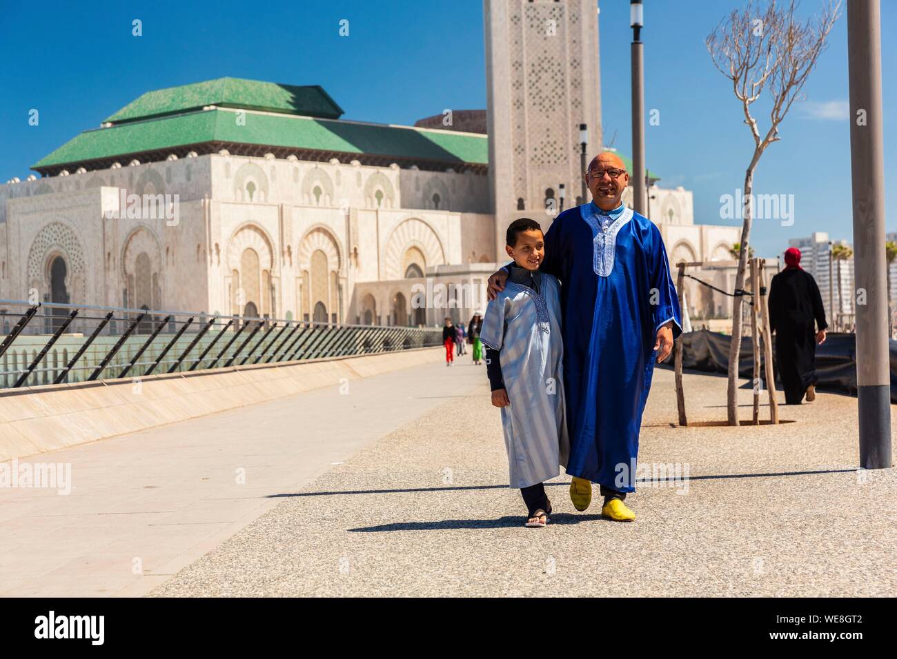 Marruecos, en Casablanca, en la plaza de la mezquita de Hassan II, padre e hijo a la vuelta de la oración del viernes Foto de stock