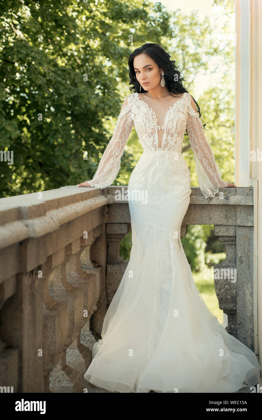 Hermosos vestidos de boda en la boutique. Feliz novia antes de la boda. La mujer se preparando para la boda. Maravilloso vestido nupcial. Elegante salón de es wai Fotografía de