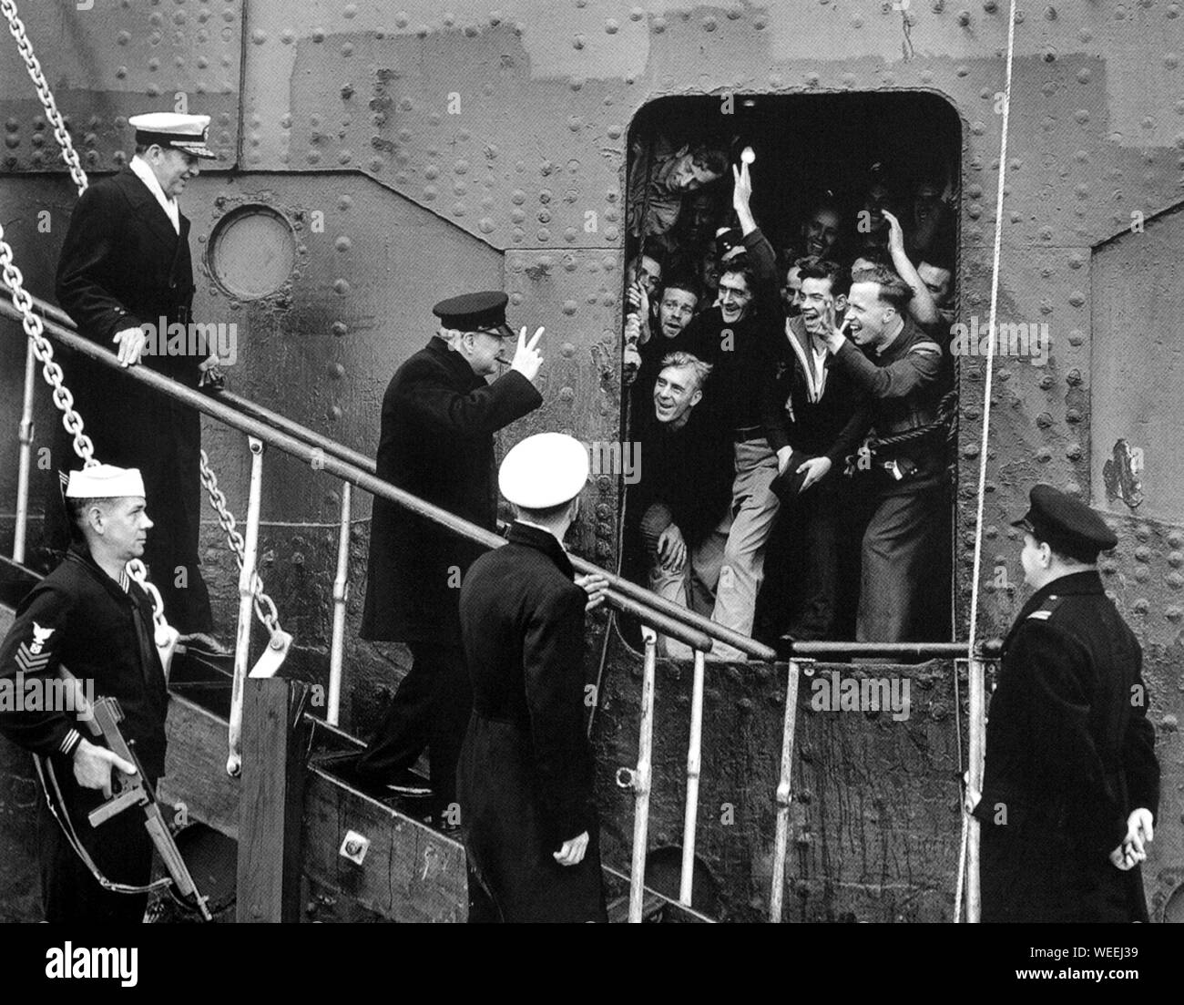 Winston Churchill llegando a los Estados Unidos por barco y siendo aclamado por marineros aliados y aviadores que también hicieron el cruce. Mayo de 1943 Foto de stock