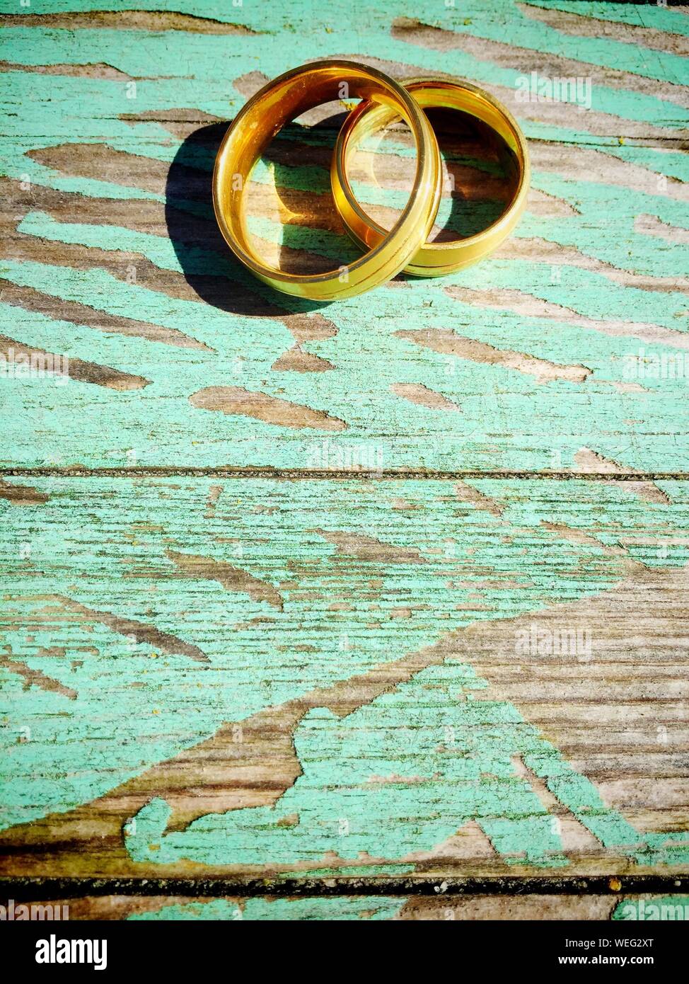 Los anillos de boda Sobre la plancha de madera. Foto de stock
