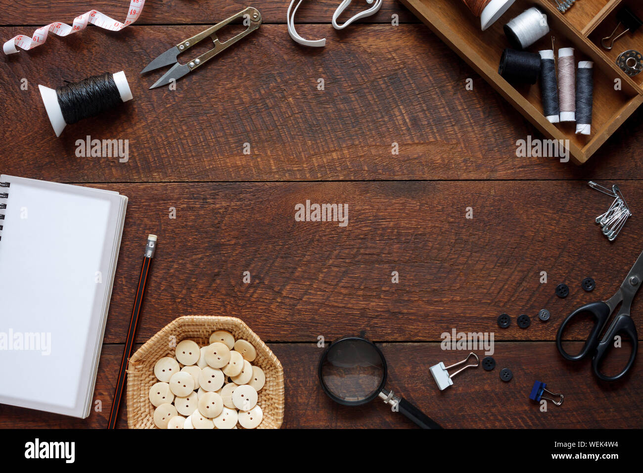Imagen aérea laicos plana del diseñador de moda artículos concepto de fondo.La vista superior o adaptar accesorios de costura en equipos modernos rústicos de madera marrón en casa Foto de stock