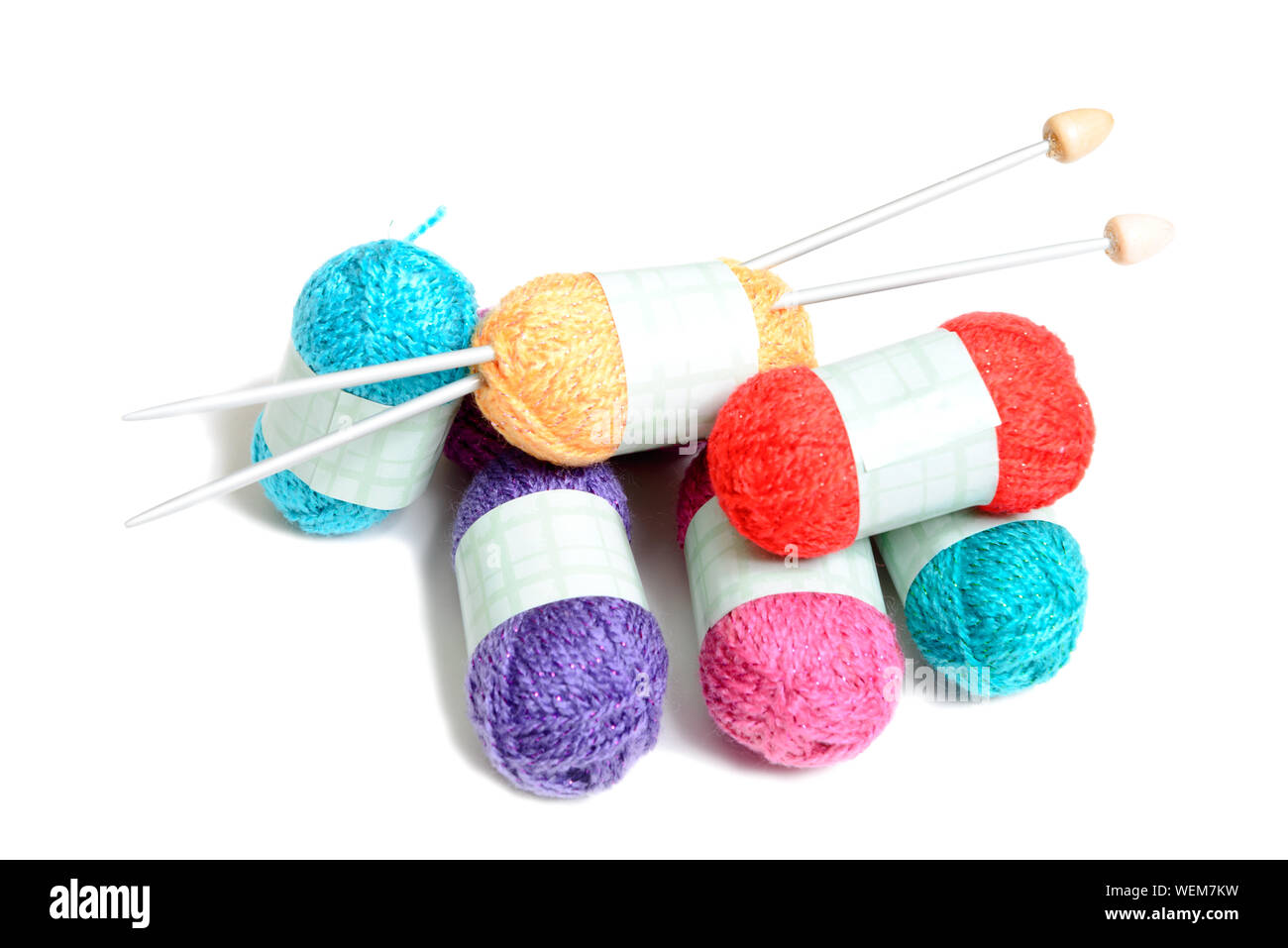 Close-up de lana de varios colores y aguja de tejer sobre fondo blanco. Foto de stock