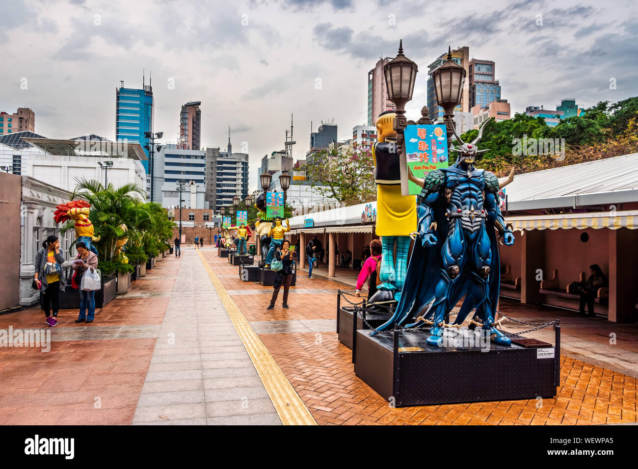 Hong Kong, China, en marzo de 2013 estatuas de personajes famosos, en Hong Kong, la Avenida de Las Estrellas cómicas, el Parque Kowloon. Antecedentes del horizonte urbano de Tsim Sha Tsui. Foto de stock