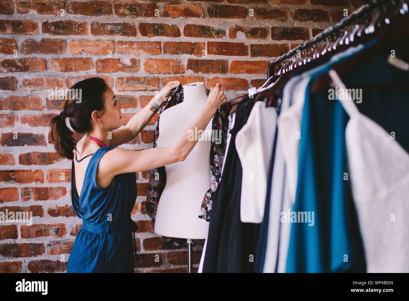 Diseñador de moda ropa de ajuste en el maniquí en el studio Foto de stock
